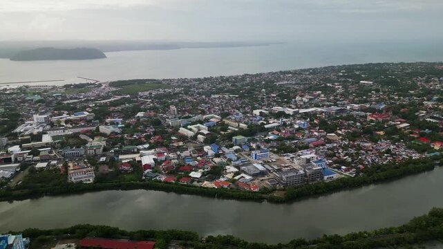 Aerial drone shot of Iloilo City in Panay Island, Philippines with dense urban districts, riverfront landscape, and surrounding coastal waters