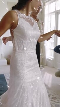 Vertical video: Bride reaching, helper holding lace dress, bride twirling for bridal shoot
