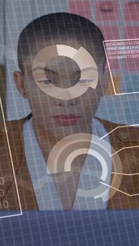 Vertical video: Woman sitting center code overlaying face causing viewing rings forming data panels