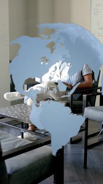 Vertical video: Man sitting typing on laptop in office, map decal shifting, revealing task progress