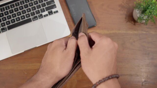 Close-up of an almost empty wallet with only coins inside, symbolizing financial stress, budgeting difficulties, and limited income.