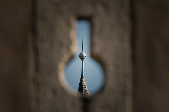 Castle turret spire seen through narrow keyhole loophole in stone wall at Rosenburg castle