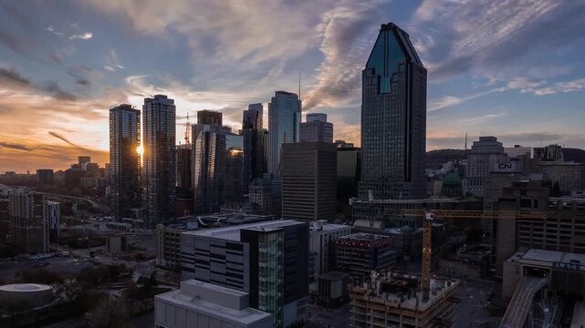 Dramatic sunrise over montreal cityscape illuminating skyscrapers with vibrant colors and dynamic cloudscape.