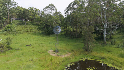 Fototapeta premium Aerial View of a Traditional Farm Windmill Beside a Small Pond