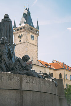 Jan hus memorial statue stands with old town hall clock tower in prague, czech republic
