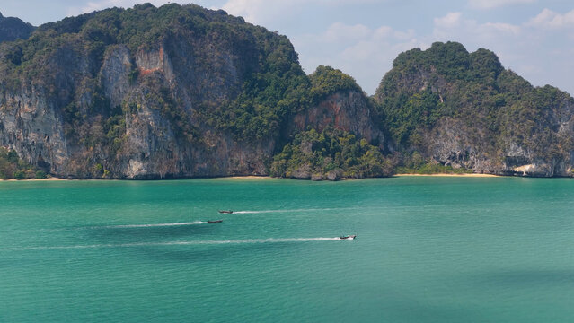 Aerial View of Longtail Boats Cruising Past Limestone Cliffs in Krabi