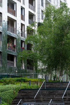 Garden stairs lead through residential architecture, where balconies and greenery soften an urban courtyard with facade detail and exterior design