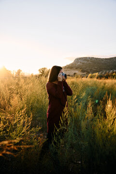 Profile of woman taking a photo with a vintage camera