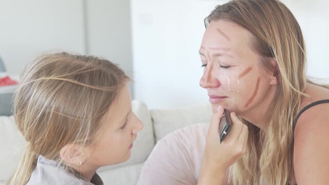 Daughter makes a makeover to her mother, girl applies nonal cream to a woman's face to cover up wrinkles, 