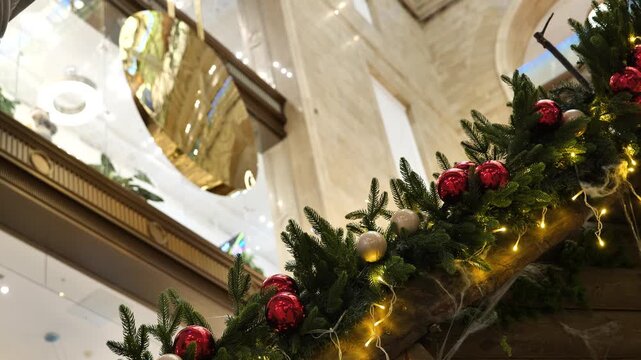 Decorated fir branches against the backdrop of a swinging clock pendulum.