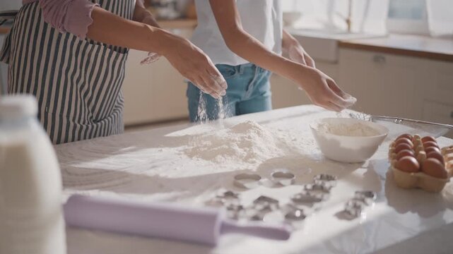 Calm sunny sunday morning at home, mom and daughter cooking dough for cookies. African american woman and her teenage daughter sifting flour for pizza or pie, make homemade bakery for family dinner