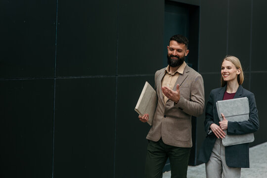 Business colleagues walking outdoors discussing business matters