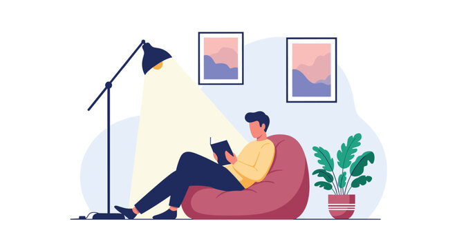 Young man relaxing in a comfortable bean bag chair while reading an interesting book under the warm light of a tall floor lamp.