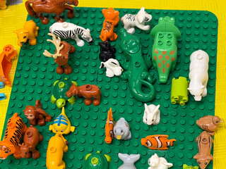 Fototapeta premium Colorful plastic animal toys on green baseplate lego