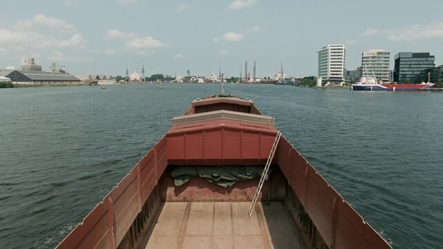 Point of view from an empty cargo ship navigating on the IJ river towards an industrial harbor area