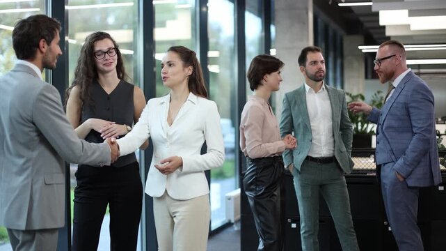 Five professionals converse in a modern office space