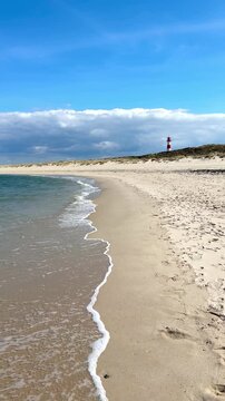 walking on the beach with sand dunes and lighthouse