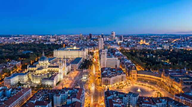 Panoramic aerial view of Madrid city center at dusk with illuminated buildings and streets.