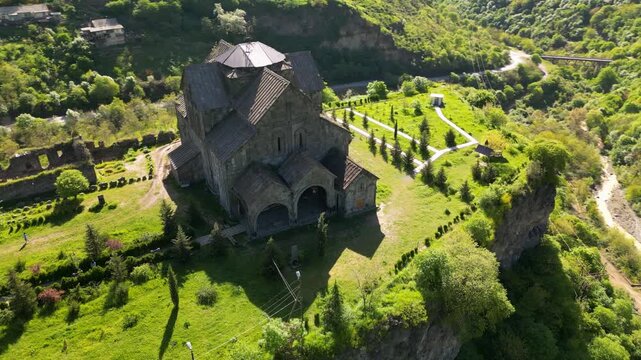 Aerial view of Akhtala Monastery, a medieval fortified Armenian monastery in Lori Province, northern Armenia. Historic Christian complex surrounded by forested hills and mountainous landscape.