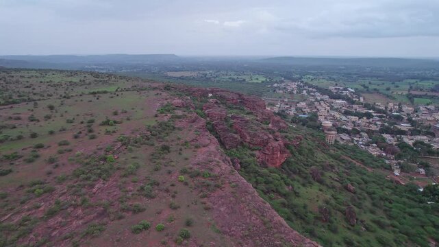 Dolly shot of Badami Caves with surrounding terrain and urban landscape