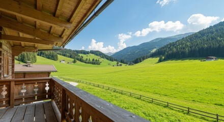 Obraz premium Wooden balcony overlooking a vibrant green valley, rolling hills, and a bright blue sky