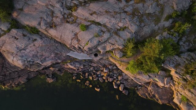 Top down drone shot rising above a giant's kettle geological feature in Hanko