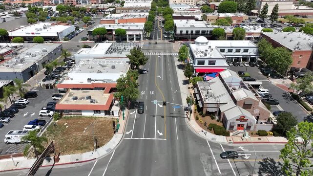 High aerial view of downtown Fullerton capturing Harbor Boulevard lined with restaurants, bars, commercial buildings, and active urban tourism in the entertainment district.