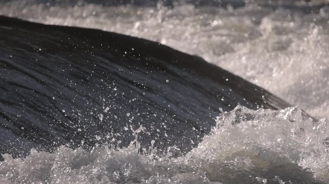 Water falling off a small river dam in slow motion. Power of the water. Energy.