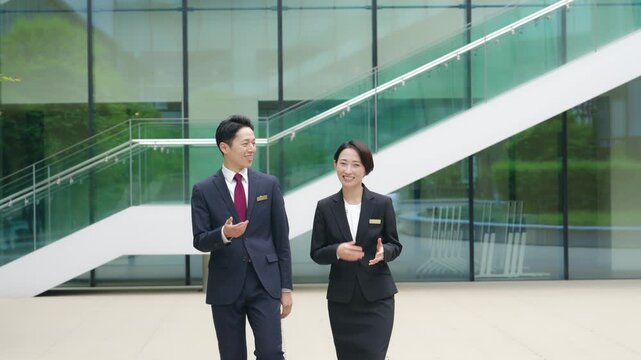 街を歩きながら会話する男女ビジネスパーソンのグループ