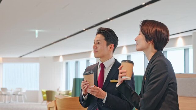 ロビーで会話する男女ビジネスパーソンのグループ
