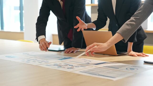 A group of business people having a meeting while looking at documents in the office.