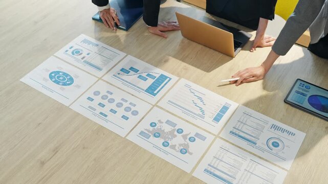 オフィスで書類を見ながらミーティングするビジネスパーソンのグループ