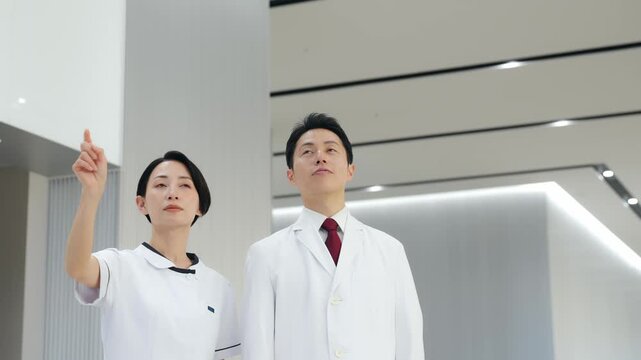 画面を見ながら相談する白衣の男女グループ