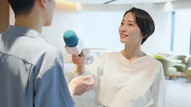 インタビューする女性レポーター