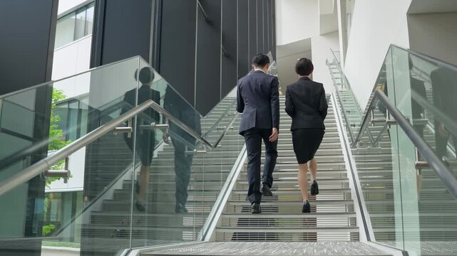 階段を登る男女ビジネスパーソンのグループ