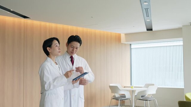 画面を見ながら会話する白衣の男女グループ