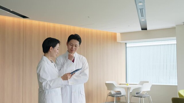 画面を見ながら会話する白衣の男女グループ