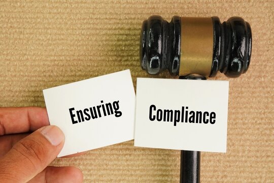 Judge's gavel and paper with the words Ensuring Compliance: To hold individuals accountable to legal and ethical standards