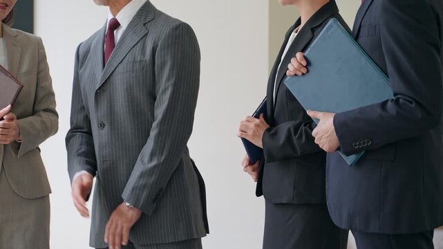 オフィスで会話する男女ビジネスパーソンのグループ