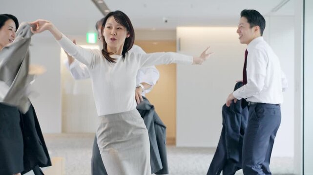 オフィスでダンスするビジネスパーソンのグループ