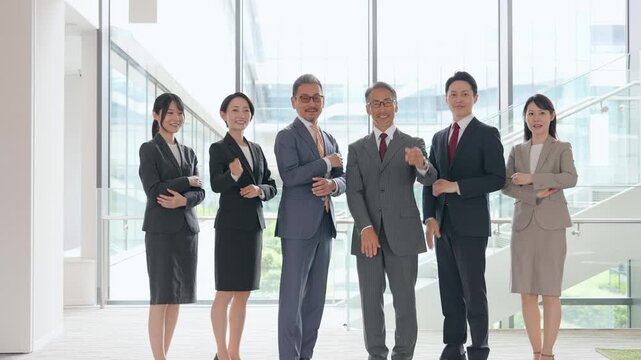オフィスでガッツポーズするビジネスパーソンのグループ