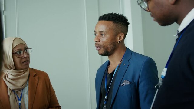 A diverse group of business professionals in a focused discussion at a conference. They are collaborating and communicating ideas during a professional networking event.
