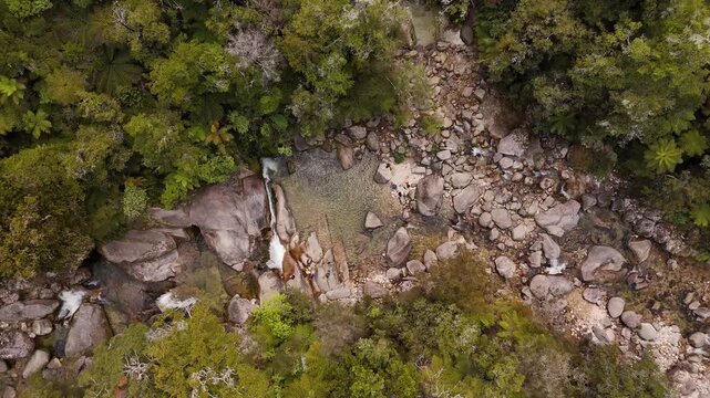 Natural rock pool and waterslide of Cleopatra's Pool in Abel Tasman National Park, New Zealand. Aerial top-down ascending, slow-motion