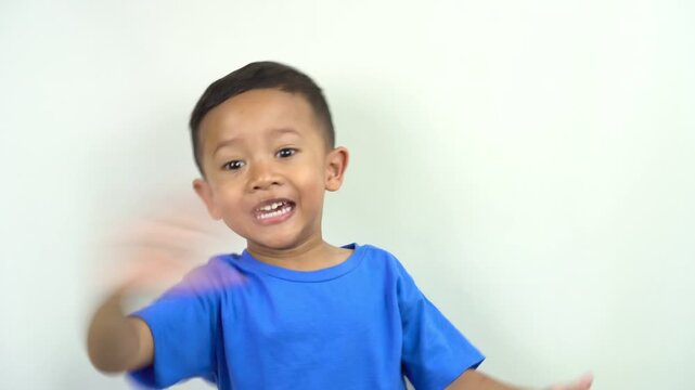 cute and funny little asian boy waving his hands making hand gestures to say good bye saying goodbye, greeting see you next time,