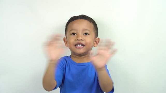 cute and funny little asian boy waving his hands making hand gestures to say good bye saying goodbye, greeting see you next time,