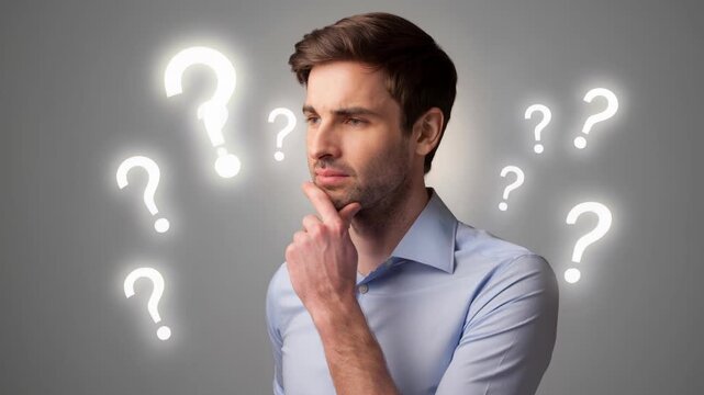Thoughtful young man surrounded by glowing question marks pondering ideas and decisions