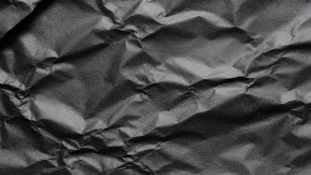 Close up of crumpled black paper texture background abstract.