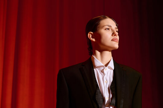 Elegant artistic woman poised on stage, capturing the essence of theatre in a vibrant performance