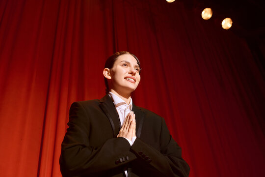 Artful expression of gratitude from a young performer on a vibrant theater stage