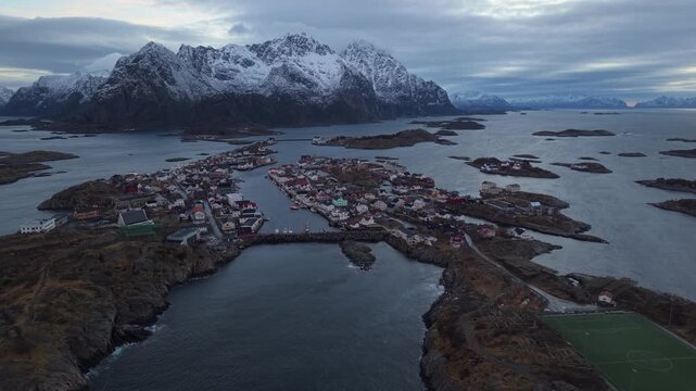 Drone view of a snowy island village in Norway during a cloudy evening
